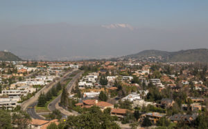 View to South from Lo Barnachea, over newly developed suburbs. Snowcapped mountains visible above the ever-present smog layer.